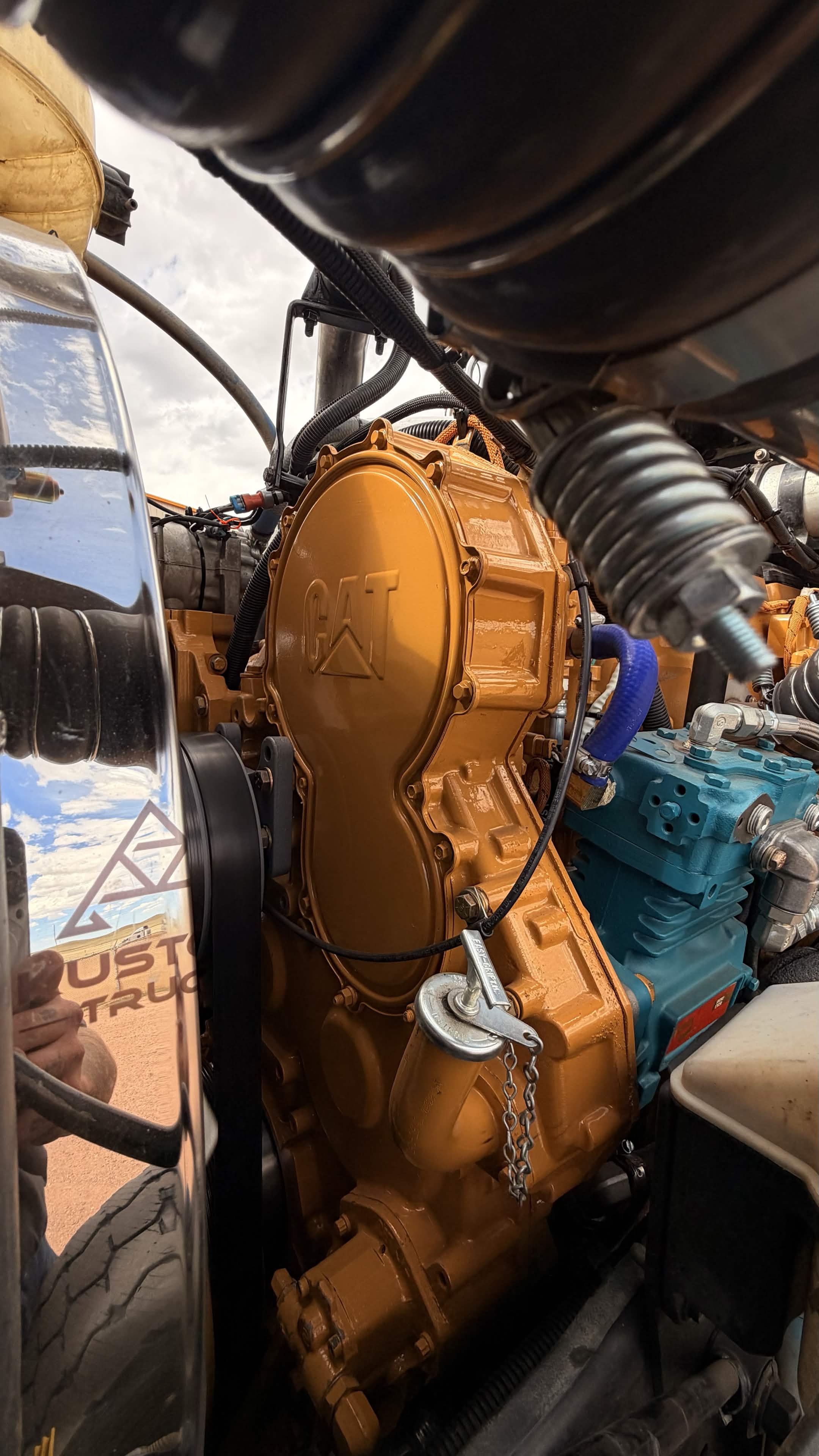 Freshly rebuilt CAT engine gear case and bell housing, painted Caterpillar yellow, installed in a heavy-duty chassis